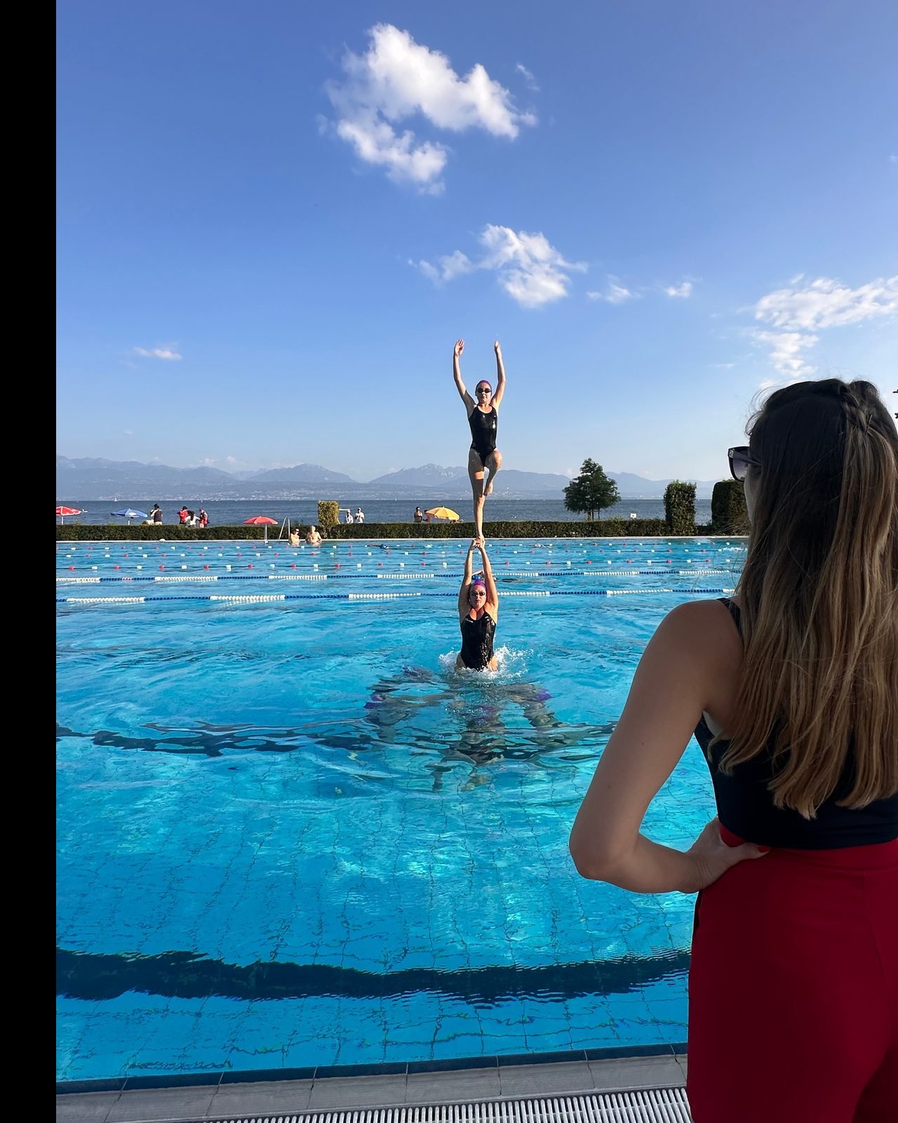 Figure de porter en piscine extérieure, lac Léman et coach en premier plan